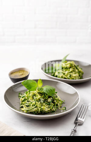 Zucchini vegan pasta in two plates on white background. Vegetarian healthy food Stock Photo