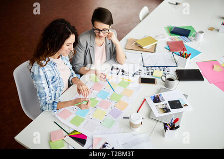 High angle portrait of two contemporary women planning project placing colorful stickers on roadmap, copy space Stock Photo