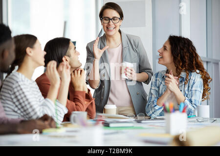 Portrait of smiling team leader talking to group of young businesspeople in meeting, copy space Stock Photo