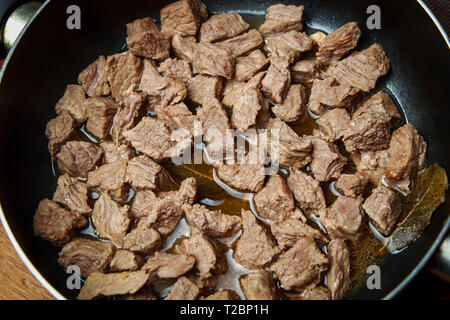 veal meat stew in a skillet with vegetables in sour cream sauce Stock Photo