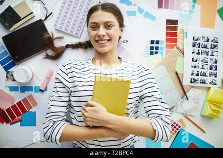 Top view portrait of contemporary young woman smiling at camera while lying over  art and design supplies, copy space Stock Photo