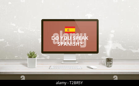 Concept of Spanish language learning online. Question Do you speak Spanish on a computer display on work desk. Stock Photo