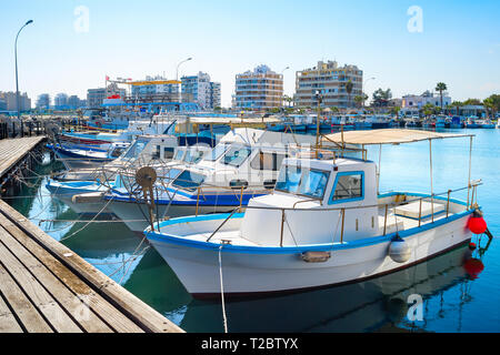 Marina with white moored yachts and motorboats, Larnaca cityscape in background, Cyprus Stock Photo