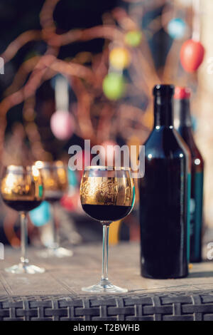 Bottle of vine, glass and easter eggs in blurry background. Spring easter concept. Stock Photo