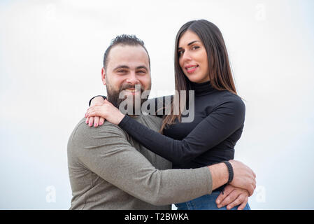 Happy couple hugging each other outdoors smiling Stock Photo