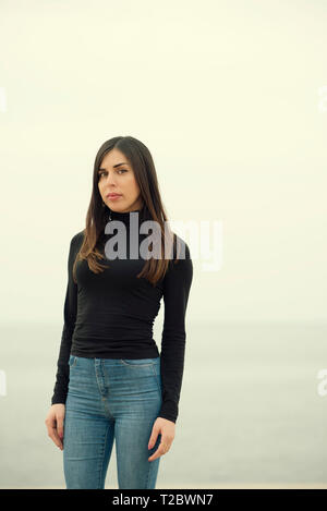 Beautiful young woman standing on the beach Stock Photo