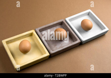 brown eggs in ceramic square plate on brown background Stock Photo