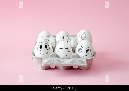 Funny Easter eggs with facial expressions. Eggs with different faces in egg carton. Stock Photo
