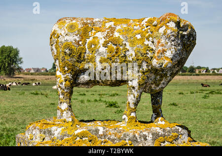 Lichen and dirt covers an old little cow sculpture on an entry gate to a cattle farm in Waterland near Amsterdam Stock Photo