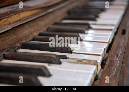 Dirty cracked keys of the old piano close-up. Retro Stock Photo