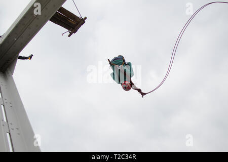 Belarus, Gomel, March 08, 2019. Jumping from the bridge to the rope.Ropejumping.A man jumps from a great height and flies on the rope in the sky. Extr Stock Photo