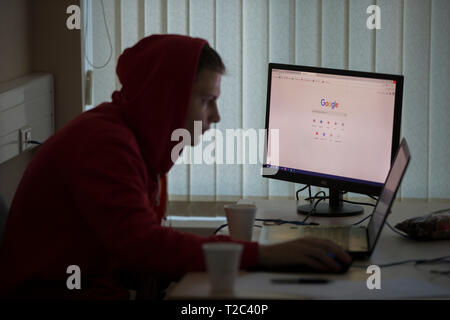 Belarus, Gimel, March 2, 2019. Business Center. Hackathon city. Computer with Google system on the background of a blurred programmer in the hood Stock Photo