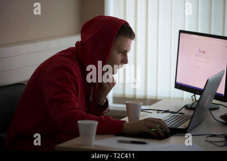 Belarus, Gimel, March 2, 2019. Business Center. Hackathon city. Teen in the hood at the computer Stock Photo
