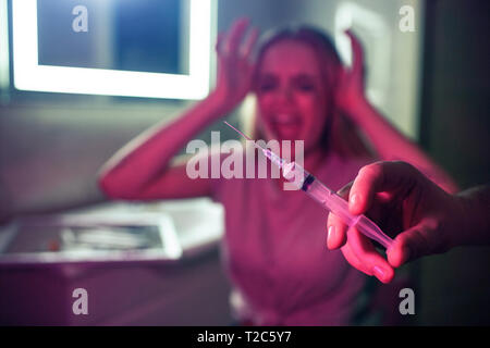 Drugs kill you. Syringe on background of screaming drug addicted woman. No to drugs. 26 June, International Day against drug abuse Stock Photo
