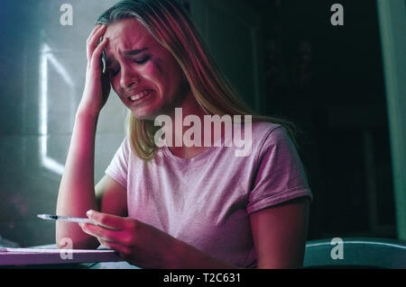 Say no to drug. Drug addict cries on drugs while holding syringe. Obsession and pain. Drug addicted woman with smeared makeup sits near cocaine lines Stock Photo