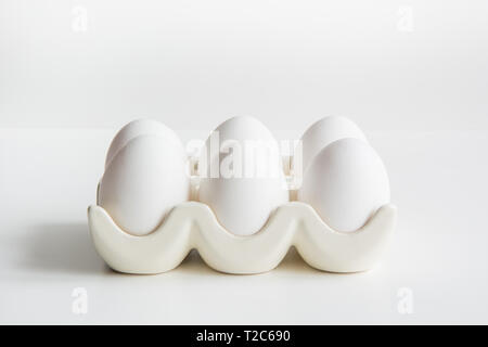 Chicken eggs in porcelain box on white. Natural healthy food and organic protein concept. Close up with copy space. Stock Photo