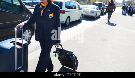 01 April 2019, Berlin: A flight attendant walks with her suitcases to Tegel airport. The BVG is on strike today, Monday. The streets are so crowded that it makes more sense to walk than to queue up at the long queue in front of the taxis or wait for the airport shuttle. Photo: Annette Riedl/dpa Stock Photo