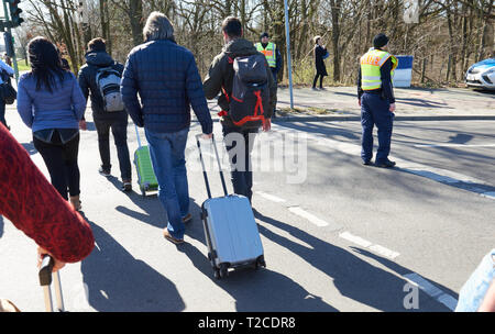 01 April 2019, Berlin: Passengers walk from Tegel Airport with their rolling suitcases to the nearest S-Bahn station. It is a 35-minute walk to Jungfernheide. The BVG is on strike today, Monday. The streets are so crowded that it makes more sense to walk than to queue up at the long queue in front of the taxis or wait for the airport shuttle. Photo: Annette Riedl/dpa Stock Photo