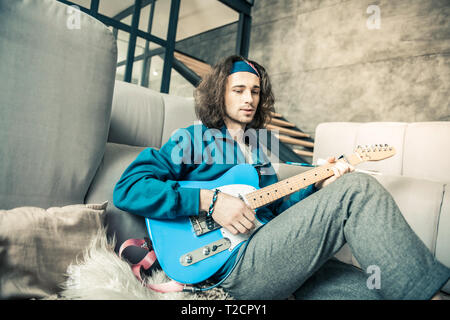 Handsome young creator with wavy hair wearing bandana Stock Photo