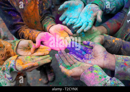 Children's hands at the Holi Parade on Liberty Ave in Richmond Hill, Queens, New York where it's customary to throw & smear colored powder. Stock Photo