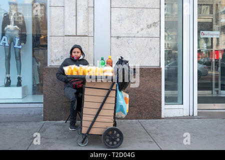 A woman most likely from South America, selling slices of Mango on East 14th Street near Union Square Park in Manhattan, New York City. Stock Photo