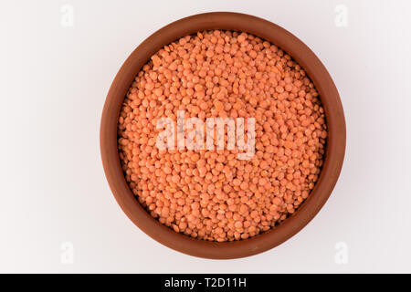Red lentils in a clay plate on a cement background Stock Photo - Alamy