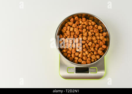 dry pet food on scales Stock Photo