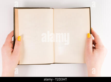 Hands holding opened book. Blank paper Mock-up Stock Photo