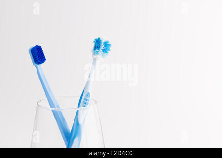 Cup with new and used toothbrushes isolated on white background. Dental care Stock Photo
