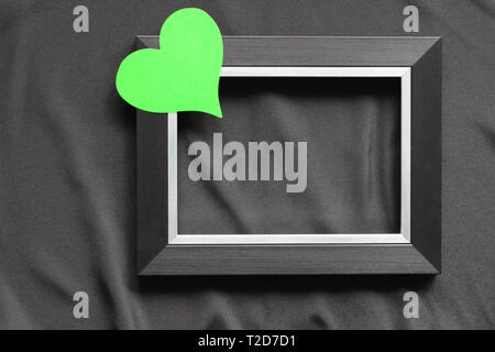 Black frame on a black background, near the heart. Flatly. Place for text. Template for postcards. Stock Photo
