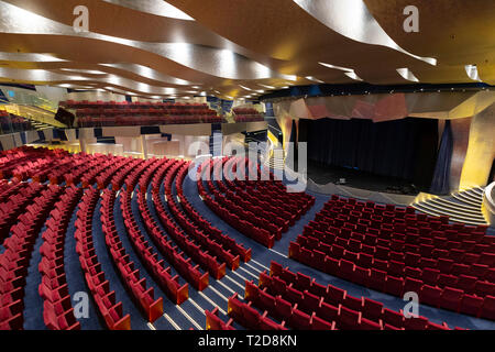 Large empty modern auditorium theater full of red seats Stock Photo