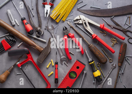 Variety of old vintage and modern household hand tools arranged as a flat lay still life on grey in a DIY and renovations concept Stock Photo