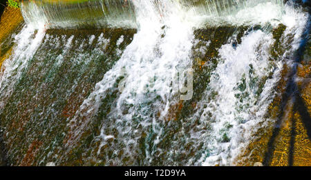 small waterfall on the urban river Stock Photo