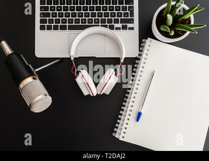 podcast recording concept with audio recording equipment on dark desk Stock Photo