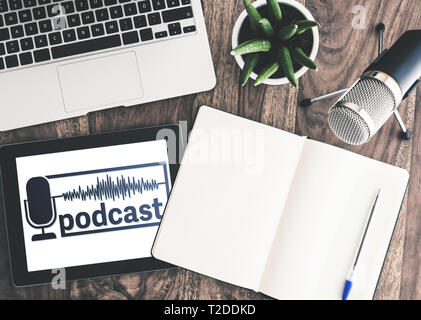directly above shot of podcast recording equipment on wooden desk with with podcast logo on tablet display Stock Photo