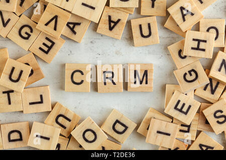 Top down view, pile of square wooden blocks with letters CRM stands for Customer Relationship Management on white board Stock Photo