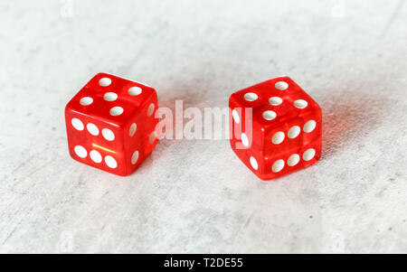 Two translucent red craps dices on white board showing Hard Ten number 5 twice . Stock Photo