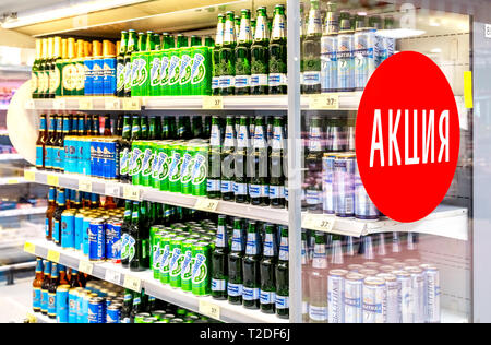 Samara, Russia - March 30, 2019: Alcoholic beverages. Various beer cans and bottles ready for sale in supermarket Karusel. Text in Russian: Action (Sa Stock Photo