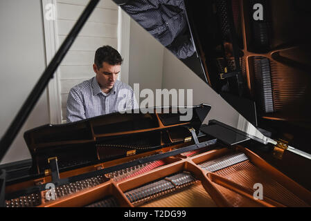 Close up of a man playing baby grand piano Stock Photo