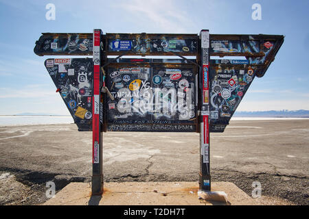 The back of the information sign at Bonneville Salt Flats in Tooele County, Utah, USA, is covered in graffiti and brand stickers. Stock Photo