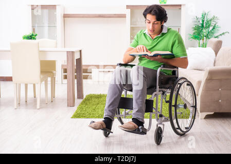 Young handsome man in wheelchair at home Stock Photo