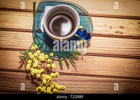 Twig of mimosa  with Coffe  in  a cup on a wood table Stock Photo