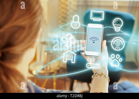 Closeup on smartphone with strong wifi signal in hand of modern woman at home. Stock Photo