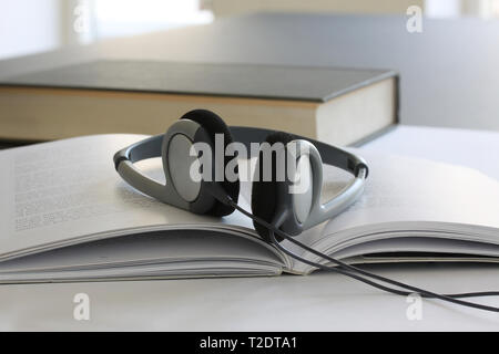 Laptop computer on working table with books, papers, pencil and headphones. Close up stock photo. Stock Photo