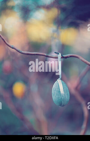 Hanging Easter eggs on tree with soft focus bokeh and color toned. Spring easter concept background. Stock Photo
