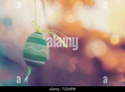 Hanging Easter eggs on tree with soft focus bokeh and color toned. Spring easter concept background. Stock Photo