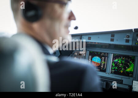Pilot in  a commercial airliner airplane flight cockpit during takeoff Stock Photo