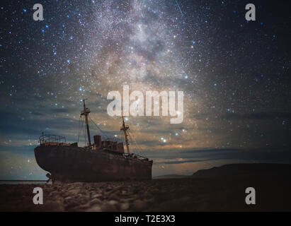 A ship wreck on a beach in chile that washed up on the beach under the stars Stock Photo