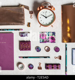 Notebooks for writing Dreams and Ideas, with different gold and maroon Stationery laying on grey background. Top View. Idea of Girly Office settings.  Stock Photo
