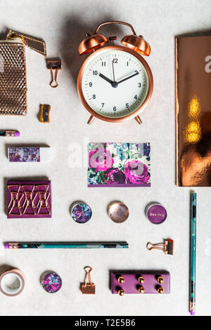 Notebooks for writing Dreams and Ideas, with different gold and maroon Stationery laying on grey background. Top View. Idea of Girly Office settings.  Stock Photo